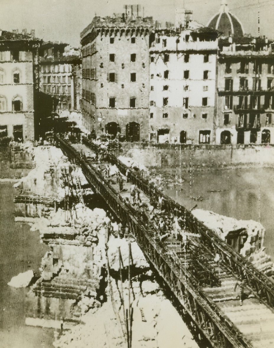 Bridge Florence Canal in Record Time, 8/19/1944. ITALY – Working with terrific speed, men of the Royal Engineers astounded the people of Florence by replacing the destroyed Ponte San Trinita with a Bailey Bridge in record time. Bridge was built on the piers of the wrecked span. Except for a few entrenched Nazi snipers, the ancient city is now completely in Allied hands. Photo by British Army Film Unit. Credit (OWI Radiophoto from Acme);