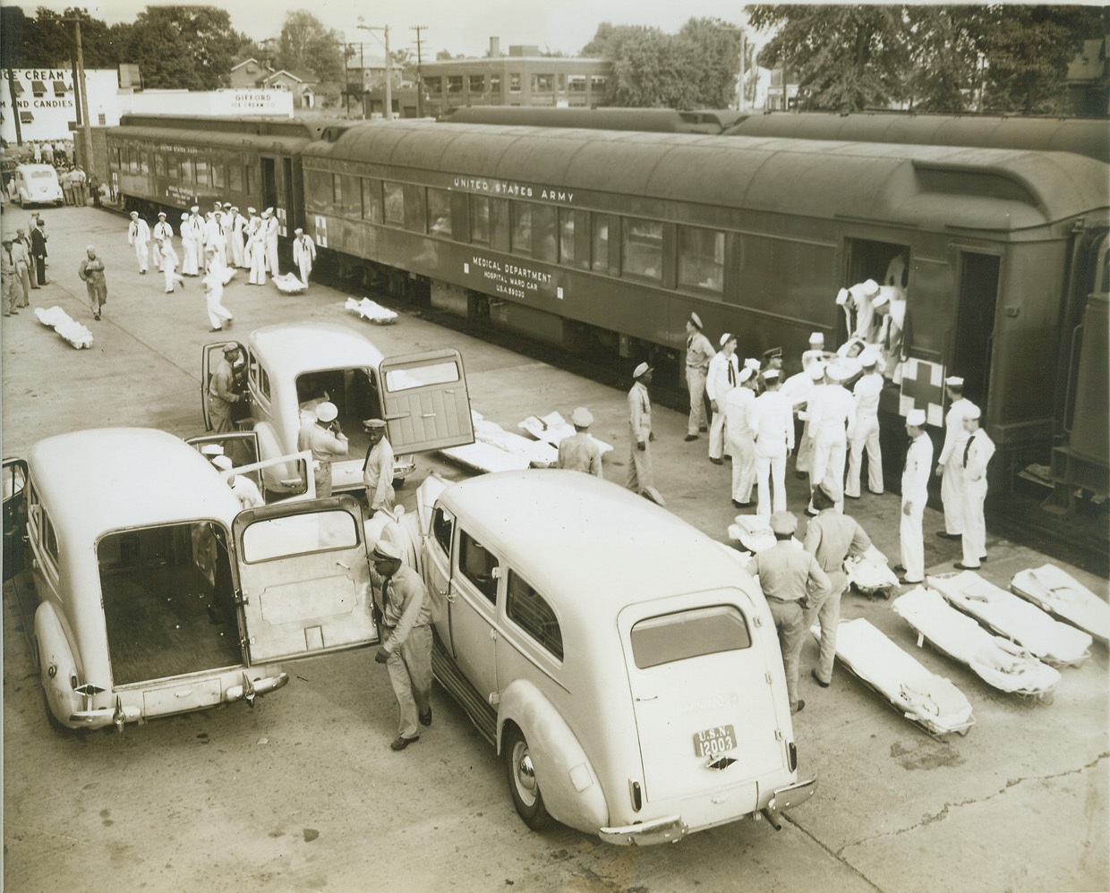 Navy's Normandy Wounded Brought Home, 8/2/1944. WASHINGTON, D.C. -- With ambulances and stretchers waiting, some of the one hundred and twenty nine Navy men wounded in Normandy are lifted from a hospital train which carried them to Silver Springs where they will receive further treatment in the Naval Medical Hospital. These Naval heroes were brought across the Atlantic from France in a hospital ship. Credit: (ACME);