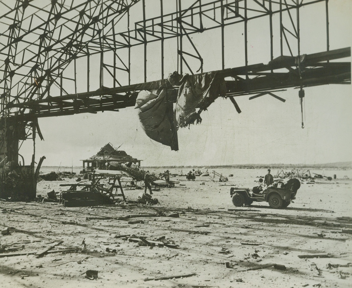 After Yank Bombardment, 8/11/1944. TINIAN – Pre-invasion naval and aerial bombardment completely shattered enemy installations and equipment at this Jap airport on the Northern end of Tinian. Marine forces captured the field shortly after hitting the beach and reconstruction of the strip is already underway. Credit: Marine Corps photo from ACME;