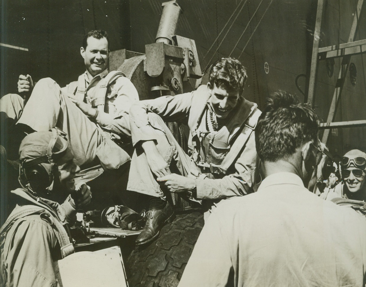 Rehashing Victory, 8/23/1944. At Sea – Relieved grins light the faces of air group 16 pilots as they discuss a victorious clash with Jap planes, after their return to their carrier.  Seated (top) are; (left to right) Comdr. P.D. Buie of Nashville, GA; and Ensign W.J. Seyfferle, Cincinnati, O.  Lower left: Ensign Edward G. Wendorf, West (co), Texas.  With back toward camera: Comdr. L.B. Southerland, USN.  Extreme right: Lt. (jg) Frances M. Fleming, Portland, Ore. Credit line (official U.S. Navy photo from ACME);