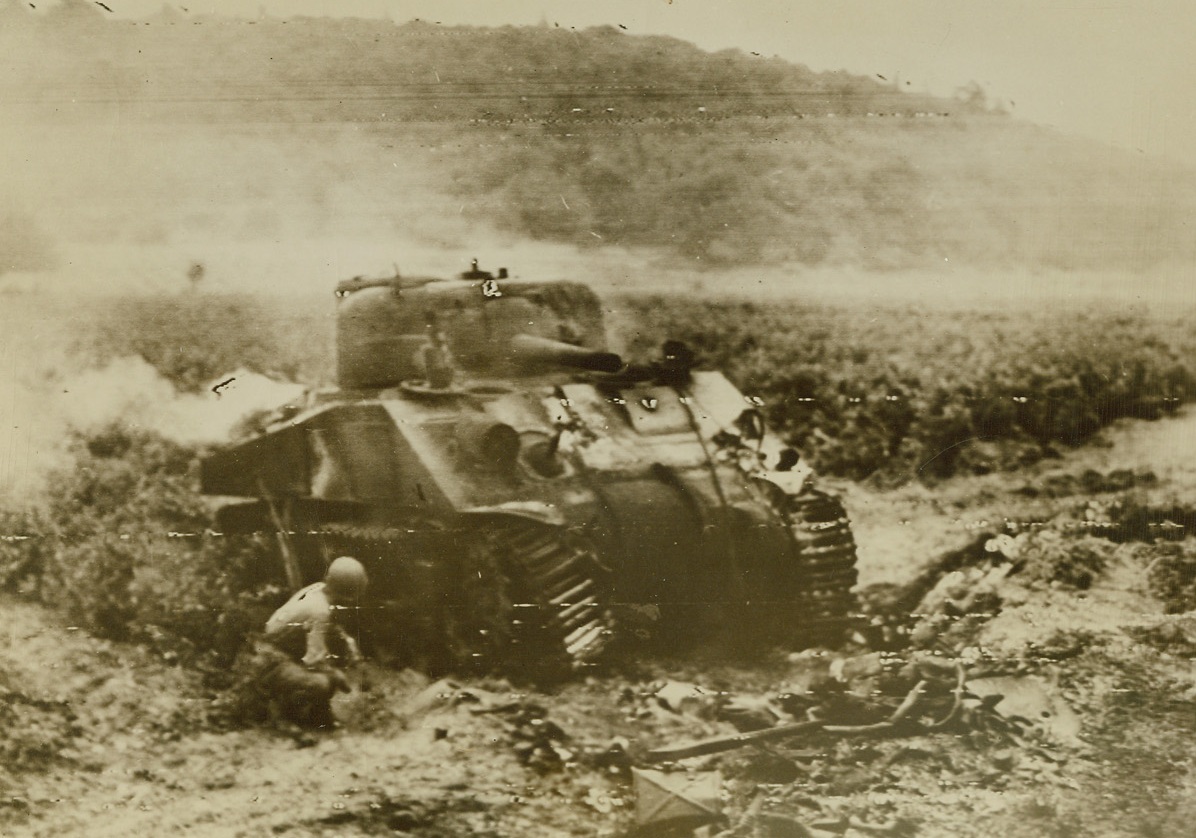 Almost a Rarity, 8/20/1944. Southern France -- A Sherman tank, which has been knocked out by a German 88, burns in a field near a town in Southern France. A U.S. soldier seeks cover beside the smoking hulk. Credit: US Army photo from ACME;