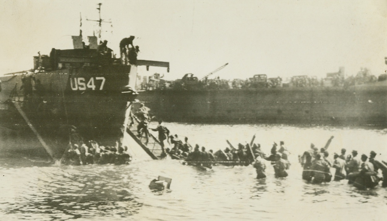 EVACUATE NAZI PRISONERS FROM S. FRANCE, 8/18/1944. FRANCE – Wading waist deep in water, long lines of Nazi prisoners are herded onto landing craft for the trip to Allied prison compounds.  They are part of the 7,000 Nazis captured in the first few days of the invasion of Southern France.;