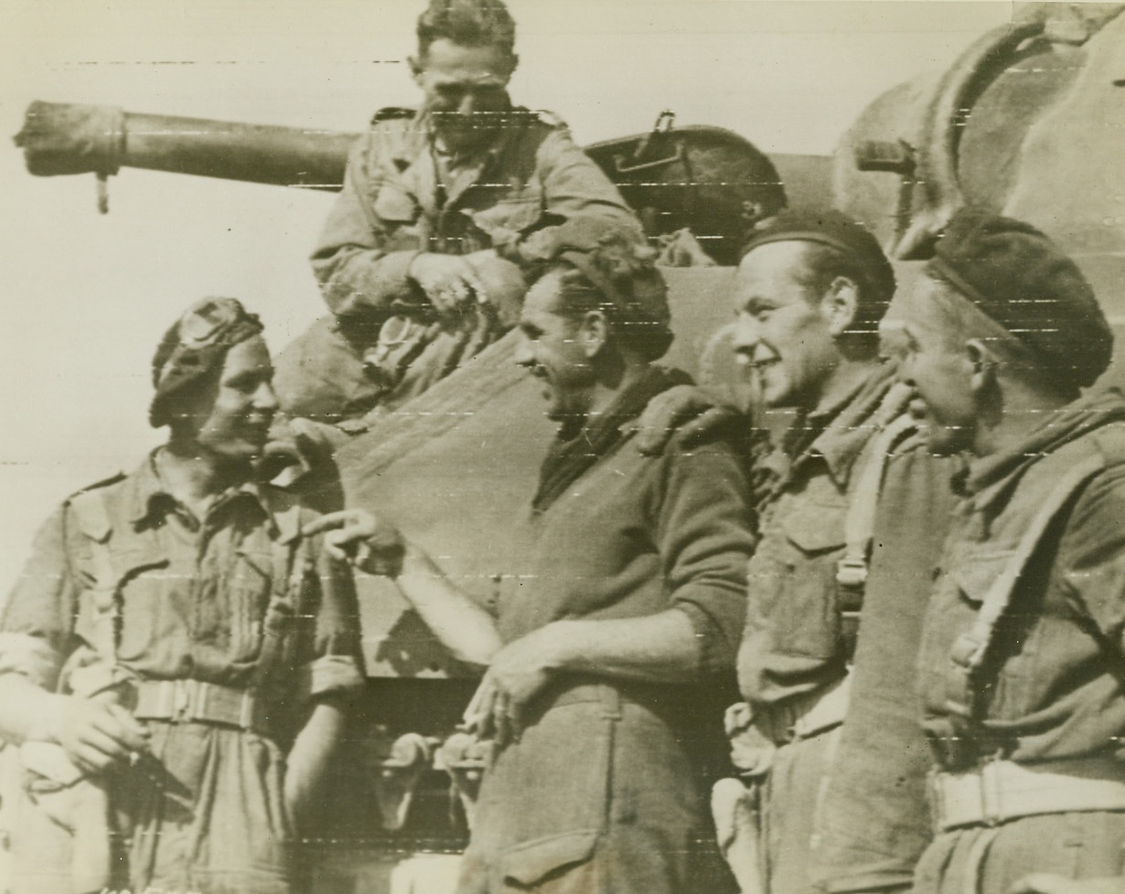 POLISH TROOPS JOIN ALLIES IN FRANCE, 8/15/1944. FRANCE – This photo, the first of its kind, shows Polish troops in action with the British and Canadian soldiers on the Normandy front.  Sgt. McVay (2nd from left), shares a joke with Polish comrades before setting off to join the attack South of Caen. Credit: British War office photo via army radio telephoto from Acme;
