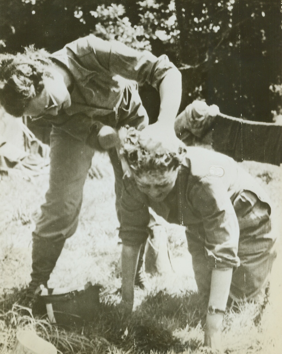 “SISTERS OF THE SUDS”, 8/3/1944. FRANCE—Two WACS take turns washing each other’s hair, with a GI helmet serving as a basin. They are: Pvt. Claire Dickman, of San Francisco, Calif. (left), and Selma Herfor, of New York City. Credit Line (Army Radiotelephoto from ACME);