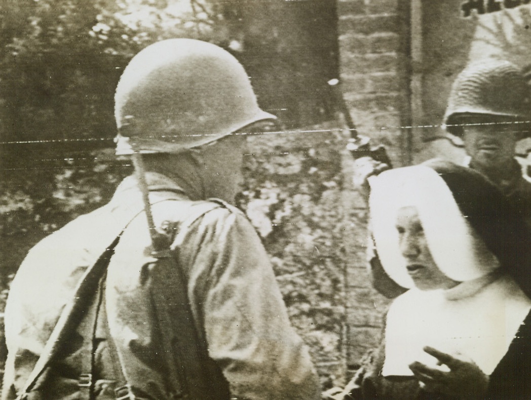NUN GIVES YANKS INFORMATION, 8/2/1944. FRANCE—A French nun gives information about retreating German forces to Yanks, who pause on their way to the Avaranches front.  Credit (Signal Corps Radiotelephoto from ACME);
