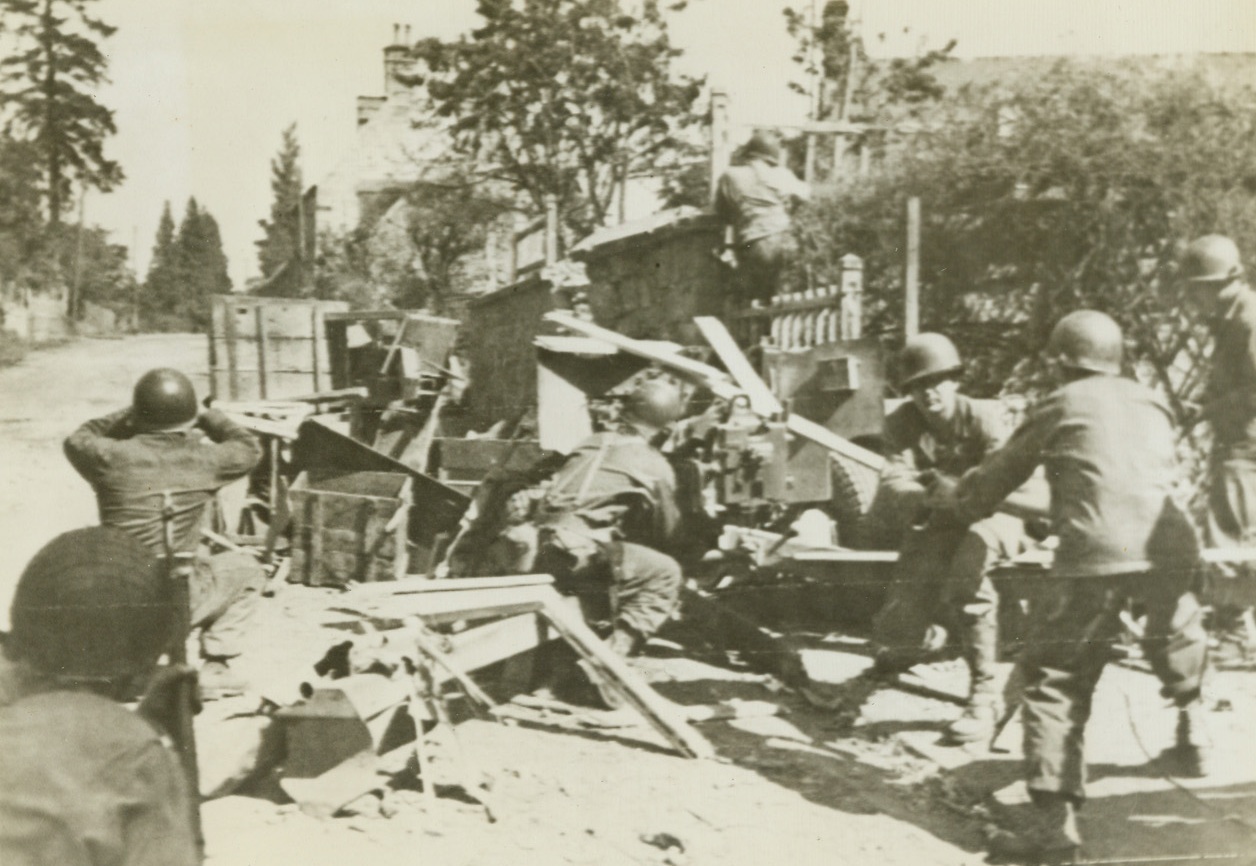 Awaiting Counter-Attack, 8/12/1944. France – Their anti-tank gun camouflaged with crates and boxes, this Allied gun crew stands ready on the outskirts of recently occupied Cherence Le Roussel, silently awaiting Nazi counter-attack. Credit: Signal Corps Radiotelephoto from ACME;