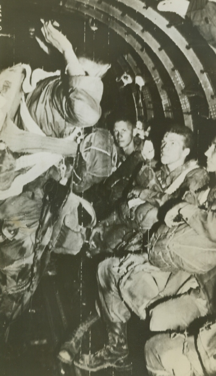 To Leap Into France, 8/15/1944. Hard and rugged Paratroopers listen intently to the Jumpmaster (standing) as he gives last minute instructions while their C-47, part of the Troop Carrier Air Division of the 12th Air Force, heads toward the dropping zone in southern France. Credit: Army Radiotelephoto from ACME;