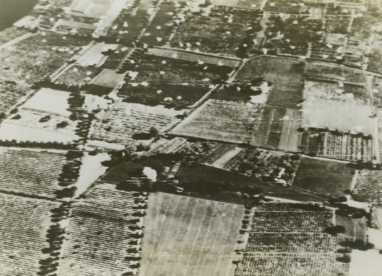 Invading Southern France – First Photo, 8/15/1944. Parachutes, left behind by Paratroopers who stuck out for their objectives in enemy territory after landing, are seen in this aerial view dotting the ground for miles around in southern France. Credit: ACME photo by Charles Seawood for the War Picture Pool via Army Radiotelephoto;
