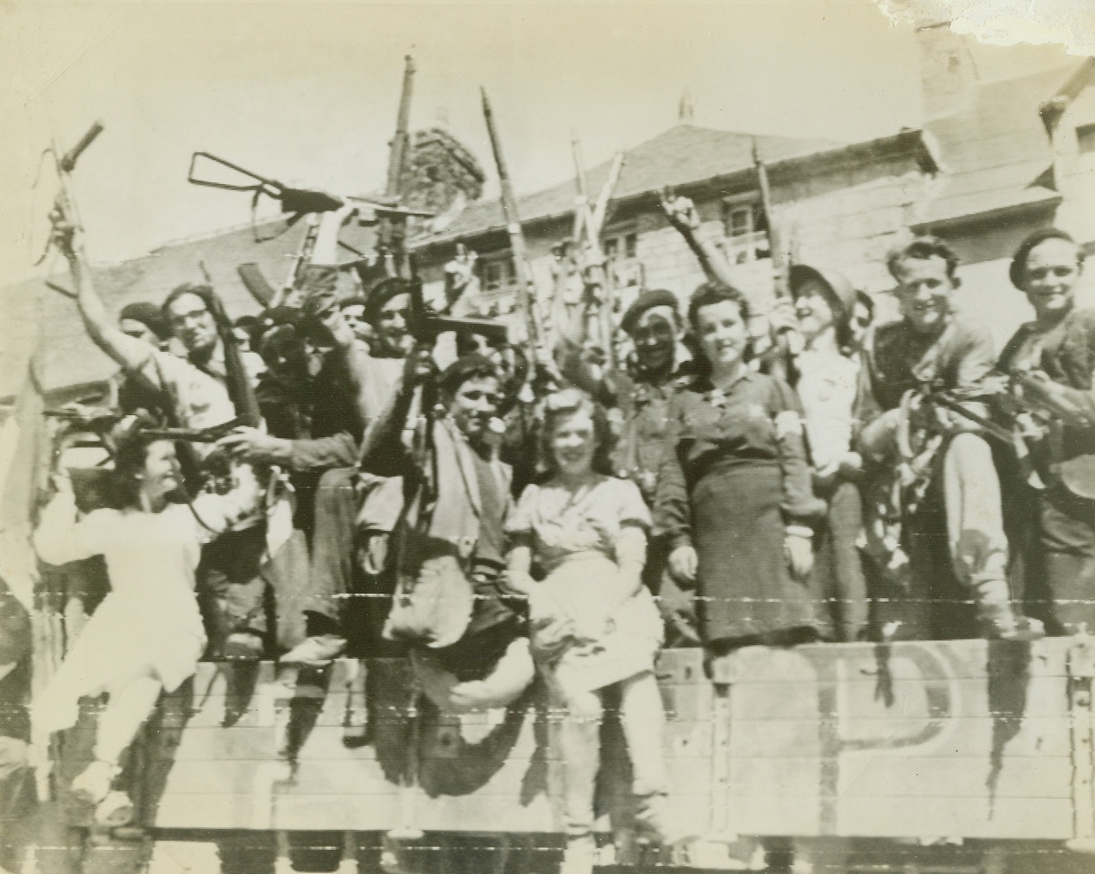 Hunting Party Searches Nazis, 8/18/1944. France – Waving captured German guns enthusiastically, these fighting Frenchmen and women of the town of Rostrenen ride off to round up stray Nazis in the vicinity after the Yanks had wiped out most of the resistance. Credit: Army photo from ACME;