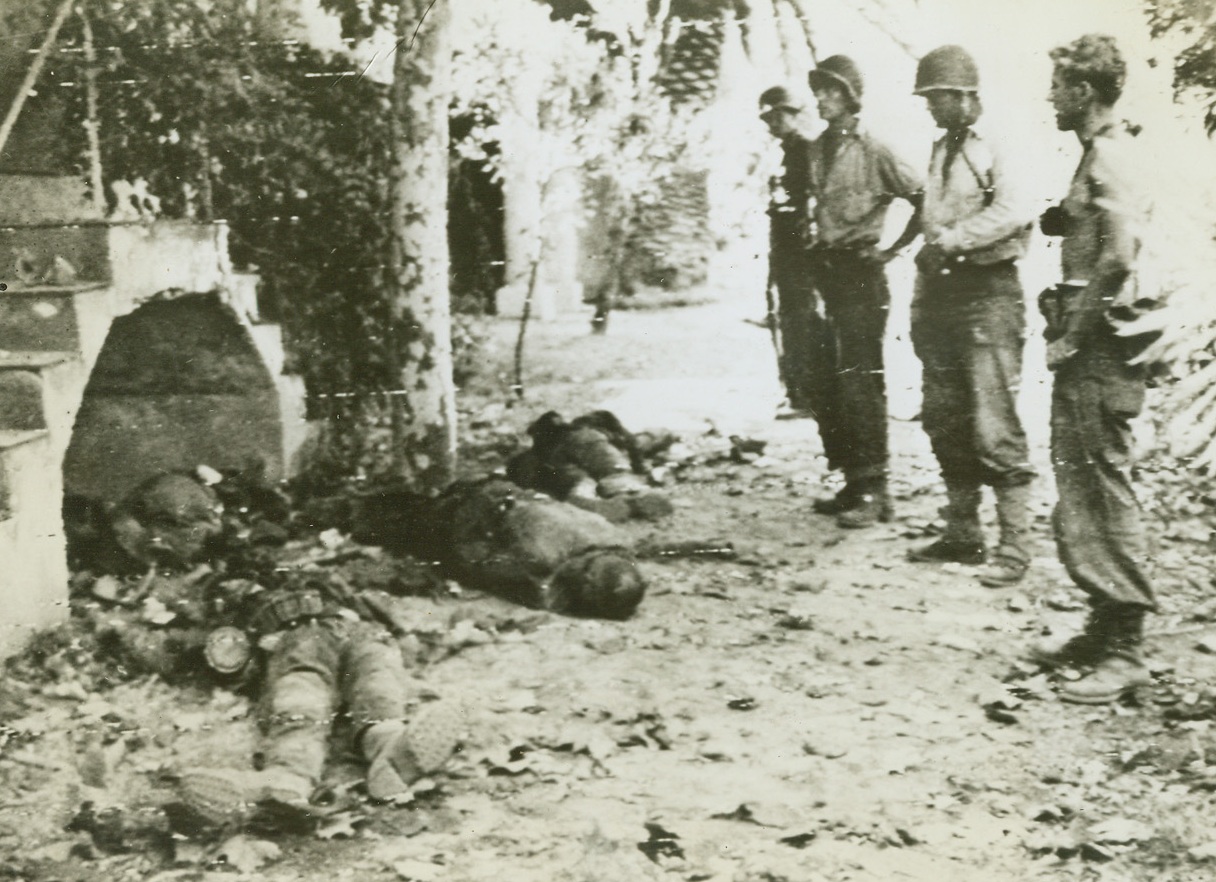 Nazis Killed in New Invasion, 8/16/1944. France – U.S. soldiers (right) solemnly view the bodies of German soldiers killed in this Allied landing east of Toulon, in Southern France. Having secured their beachhead, Allies are driving inland proceeding according to plan. Credit: Army Radiotelephoto from ACME;