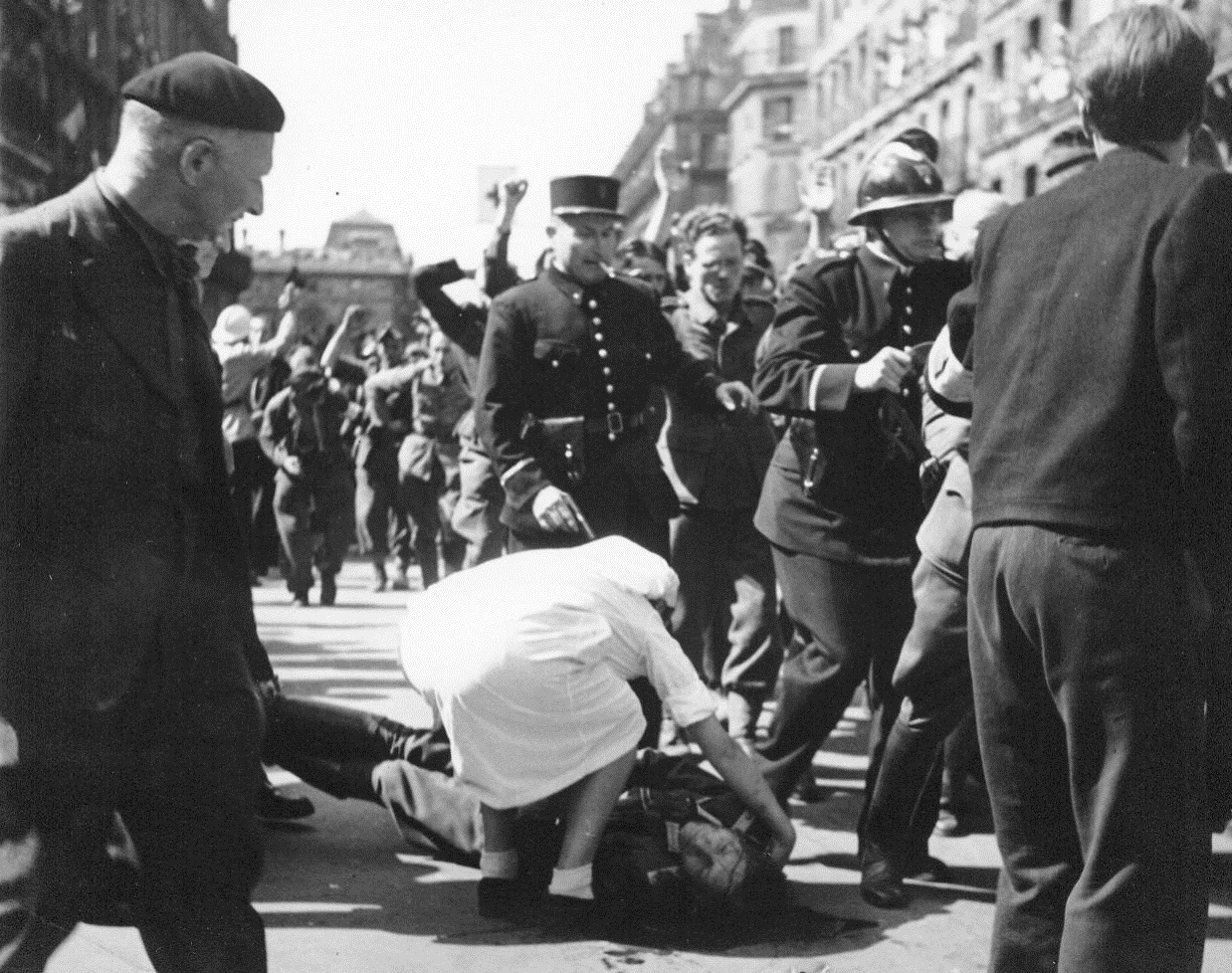 Resistance Roundup, 8/28/1944. Paris -- Lying wounded in the street, a German Officer gets the attention of a Red Cross worker as French patriots round up Nazis and collaborators  after street fighting in liberated Paris. Resistance snipers still terrorize the populace of the French capital. The allies have left the job of restoring order in Paris to the French. 8/28/44 (ACME);