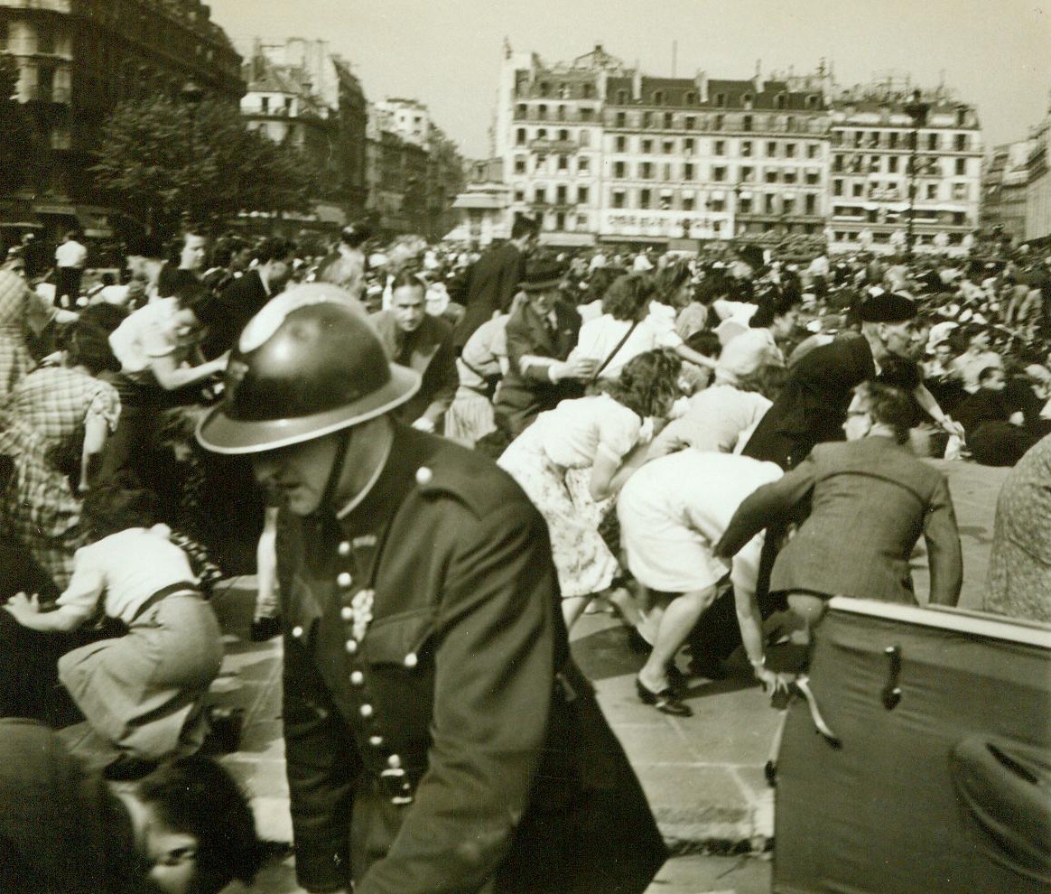 Panic In Paris, 8/28/1944. Paris -- Bending low and scurrying for cover, frightened Parisians try to escape the bullet whistling down from rooftop sniper nests. Panic reigned as street fighting broke up the official reception of General Charles De Gaulle in the French capital. 8/28/44 (ACME);