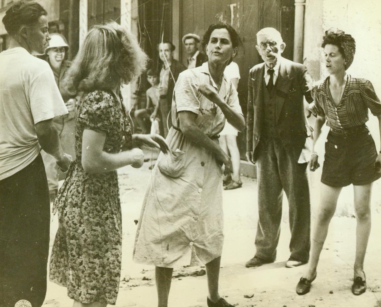 French Women Have It Out, 8/31/1944. France -- Two women, one a pro-Nazi, the other a patriot, engage in a street bout in a town in Southern France. A girl in shorts verbally blasts the Nazi-lover and an old man standing aside adds his thoughts of hatred into the fray. Women in center is object of derisive side glances from all who pass. With the liberation of this town, Brignoles, many of the men and women who were Nazi sympathizers were immediately rounded up by the Free French Partisans. 8/21/44 (ACME);