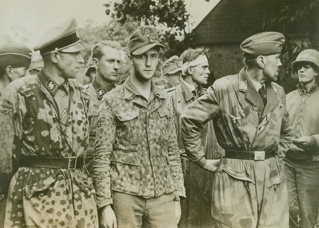 Cream of the Wehrmacht, 8/8/1944. FRANCE – Their faces hard and sullen, mirroring the determination that made their crack SS division (the Second Armored) fight almost to the last man against Allied arms, these Nazi officers of the famous “Goek von Berltchingen” regiment are lined up by their American captors, near Avranche. Credit: (ACME) (WP);