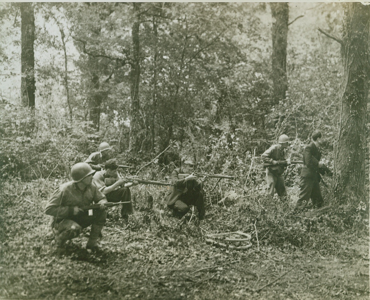 French Patriots Join Yanks, 8/5/1944. FRANCE -- American soldiers get valuable assistance from a group of French patriots in hunting down Nazi snipers during mop up operations in a wooded sector outside a town. In Brittany these patriots have given invaluable aid and are credited with being partly responsible for the great speed of the American push. Credit: (ACME);