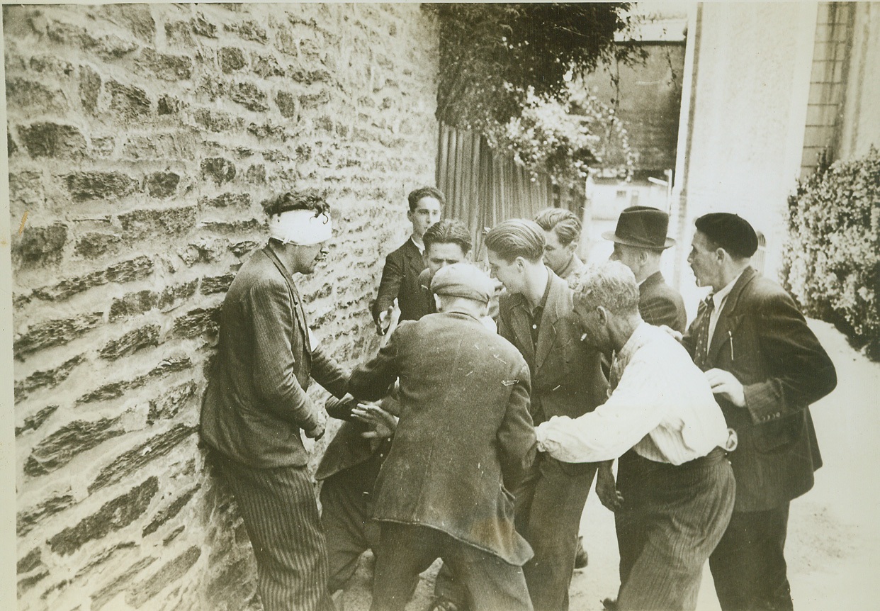 Paying for His Treachery, 8/12/1944. RENNES, FRANCE -- Angry citizens of Rennes wreak vengeance on a collaborator, captured after the Allies took the town. With his back against a wall, the traitor tries vainly to protect himself from blows of the angry people. (Man with bandage is not collaborator).  Credit (ACME) (WP);