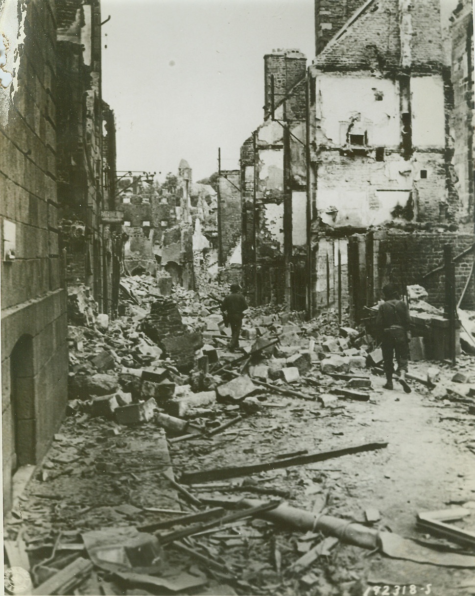 Here Lies Vire, 8/14/1944. VIRE, FRANCE -- Allied soldiers make their way through this street in Vire, scrambling over the debris which blocks their way. The French city was laid in ruins by the terrific bombardment preceding the Allied entry into the city. Credit (US Army Official Photo from ACME);