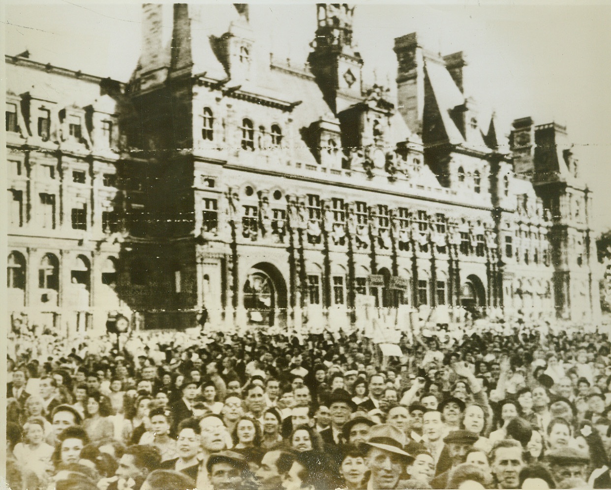 Celebrants Mass in Paris Streets, 8/28/1944. Paris—With faces reflecting the joy of being free once more, Parisians mass in front of the Hotel de Ville in Paris to celebrate the liberation of their city. Shortly afterward, as their voices raised in triumphant cheers for Gen. de Gaulle, shots rang out over their exuberant voices as snipers preyed on the assembly. The General, leading a triumphal procession, narrowly escaped death or injury.  Credit: Signal Corps radiotelephoto from ACME;