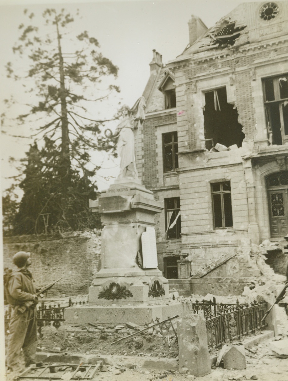 Before the ruins, 8/5/1944. France—Before the ruins of a war torn house in Periers, Normandy, Sgt. F. Clark, Marblehead, Mass., gazes at the statue of peace that somehow escaped damage. Only the pedestal has been chipped by shell fragments. With the rapid Nazi retreat on all fronts, this statue becomes a definite sign of the times.  Credit: ACME;