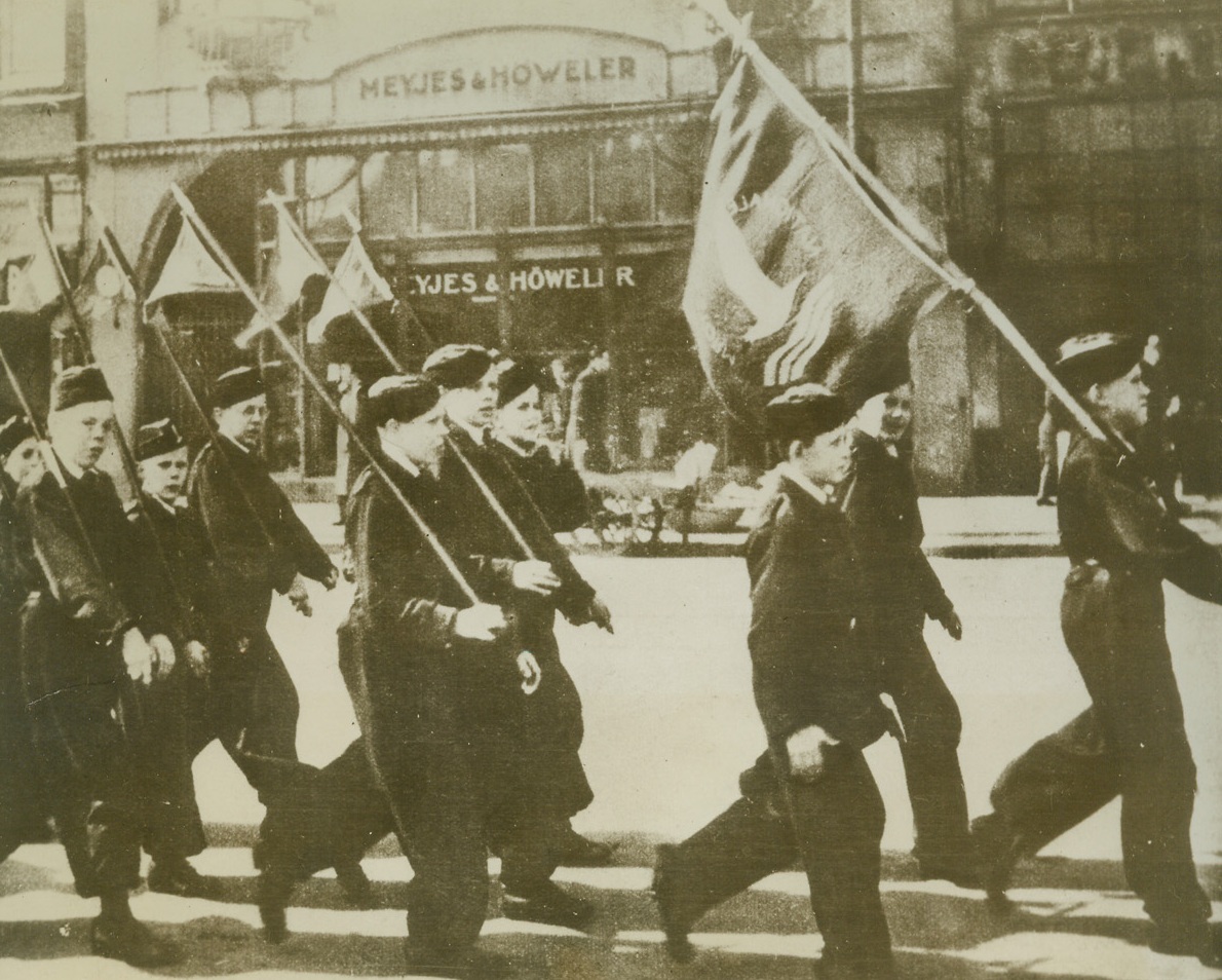 Dutch Youth Trained in Nazi Style, 9/20/1944. According to the German caption which accompanied this photo received through a neutral source the parading boys are members of the Dutch “Jeugdstorm.” They are marching with banners flying through the streets of Amsterdam.Credit Line (Acme);