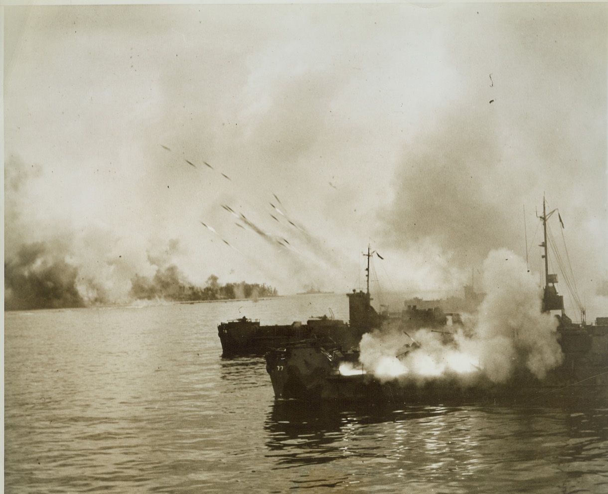 Marine Landings Heralded by Rockets, 9/26/1944. PELELIU IS. -- In the first pictures released of the new rocket weapons, landing craft of the Pacific Fleet direct rocket barrages against the beaches at Peleliu before invading 1st Division Marines landed on the island. The beach can be seen in the background, engulfed with smoke from rocket hits. Credit (Official US Navy Photo from ACME);