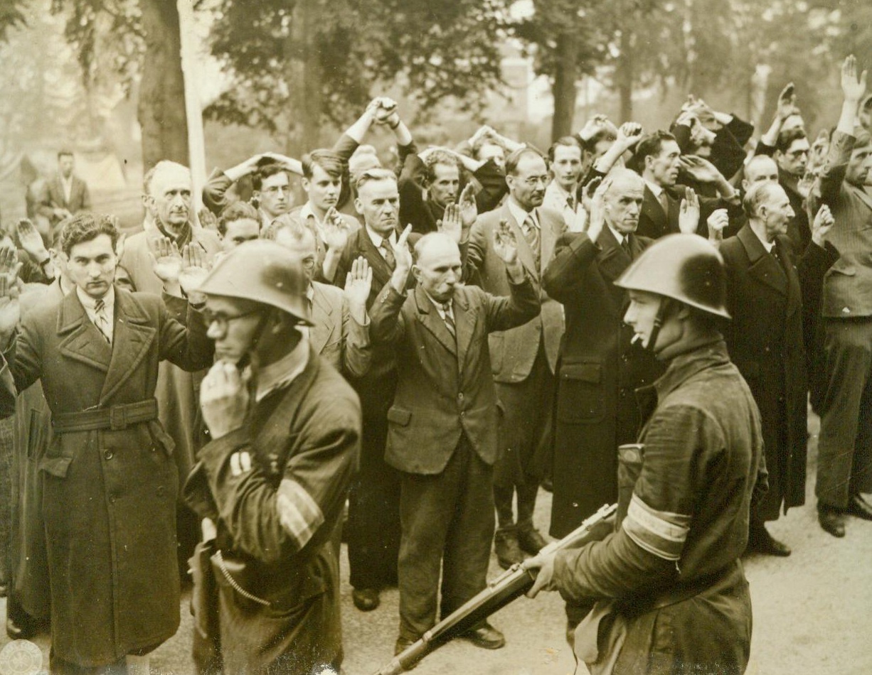 Their Day Has Passed!, 9/27/1944. Citizens of Nijmegen, Holland, accused of collaborating with the Nazis, are rounded up by fellow townsmen, carrying weapons and wearing Dutch Army Helmets. Note the varying shades of fear on the faces of the prisoners 9/27/44 ACME;