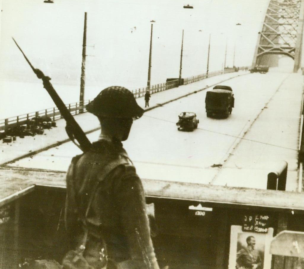 British Watch Over Rhine, 9/24/1944. Germany – With gun on his shoulder, a British soldier stands in his command post over looking the captured bridge across Waal, the Rhine’s main outlet to the sea. Note the Hitler photo on the inside of the sentry box 9/24/44 (ACME);