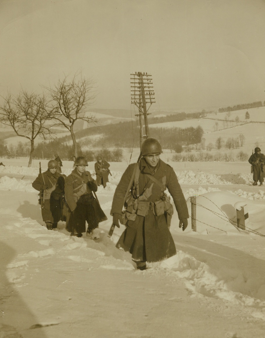 BREAKING THE TRAIL, 1/21/1945. BELGIUM—Snow scenes make lovely pictures, but for Yanks who have to fight and live in it, it’s not so nice. Here, troops of the US 1st Army in Belgium cut across snow-covered fields and through drifts as they advance to bea the Germans back into their homeland.Credit: Photo by Harold Siegman, Acme War Pool Correspondent;