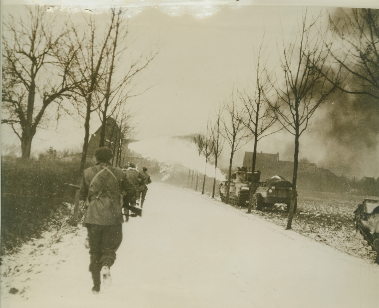 Flame-Throwers Aid British Advance, 1/30/1945. HOLLAND -- A crocodile flame-thrower fires at enemy positions as British infantrymen move along the road to St. Joost, in the Sittard battle area. Tommies faced stiff resistance before taking the village. Credit (British Official Photo from ACME);