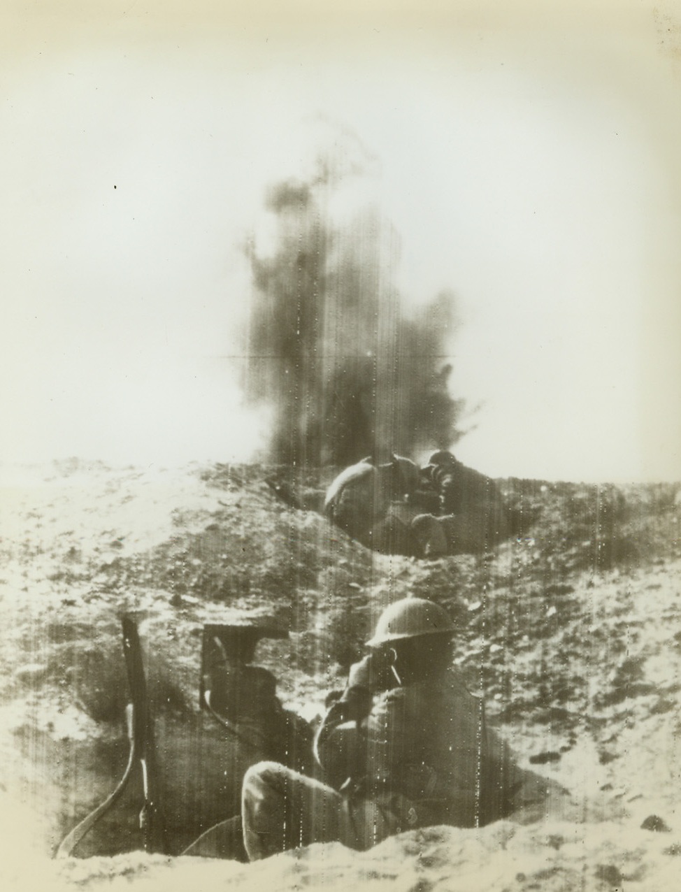 Under Fire, 12/30/1940  Somewhere in Libya—Communications men stationed at a forward observation post carry out their duties under heavy shell fire during one of Rommel’s delaying actions, fought west of Agheila, which failed so dismally. Latest reports on the British 8th Army indicate that the Allied troops have broken across the Wadi Bel-el-Chebir, the first of the remaining three possible lines of defense along the Libyan coast. Passed by censor. Credit: ACME radiophoto.;
