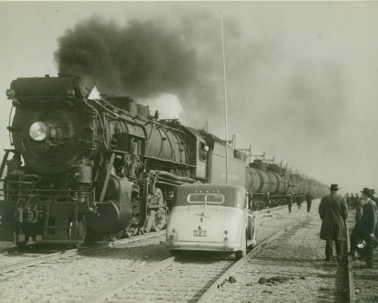 FIRST LOAD OF OIL LEAVES FOR EAST, 2/20/1943. NORRIS CITY, ILL.: Ninety-six tank cars loaded with oil at the local terminal of new Texas-Illinois Pipeline, are shown made up into the first train to leave the terminal for the petroleum starved East Coast. Formal ceremonies were held at the opening of the service. The 24-inch pipe line will be extended from here to New York and Philadelphia in the near future, but the pipe-rail system will relieve present shortage in the East until the entire line is completed. Credit: OWI Radiophoto from ACME;