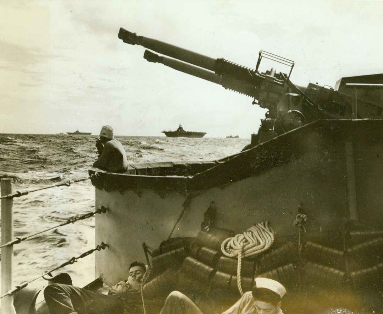Navy’s Hard-Hitting Carrier Forces, 2/14/1943. Beneath a warship’s dual purpose guns, a pair of carriers of the 25,000 – ton Essex class steam toward Wake Island in one of the first combat photos of the new flat-tops. Starting with a blow at Marcus Island on Sept. 1, they have followed up with attacks on Wake Island, October 5-6; Rabaul, November 5 and 11; Makin and Tarawa, November 20, and are presently engaged in assaults on the Marshalls and Nauru. 12/14/43 Credit (Official U.S. Navy Photo From ACME);