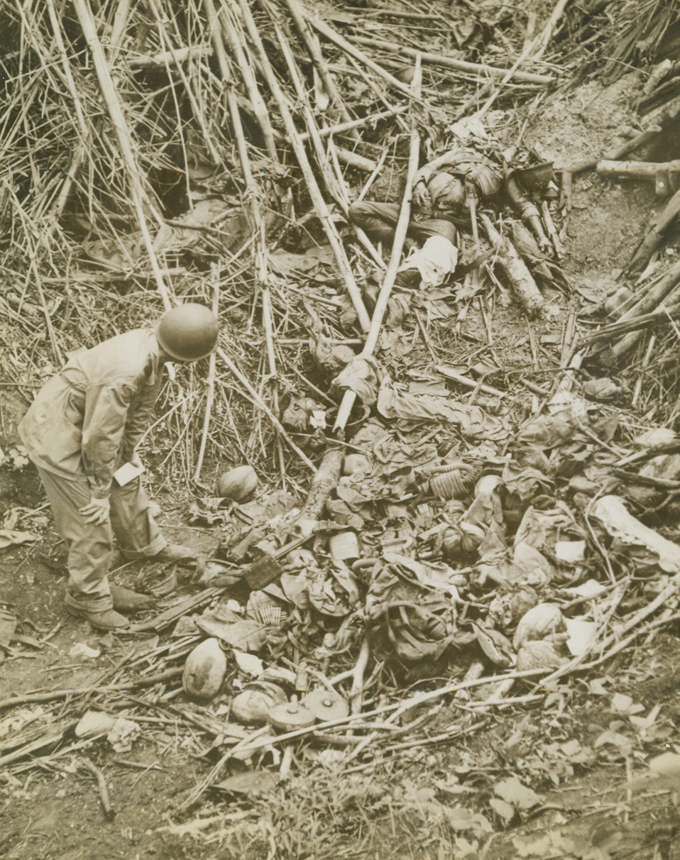 Jap Blasted in Dugout, 2/16/1943. Guadalcanal – A U.S. soldier inspects a blown-up enemy dugout which contains a beheaded Jap (upper right), scattered equipment, and many cocoanut husks which indicate that the Japanese were hard-pressed for food during their last stand on Guadalcanal. The weakened condition of the enemy troops taken prisoner on the island indicate that hunger, as well as American bullets, broke their resistance. Credit: ACME;