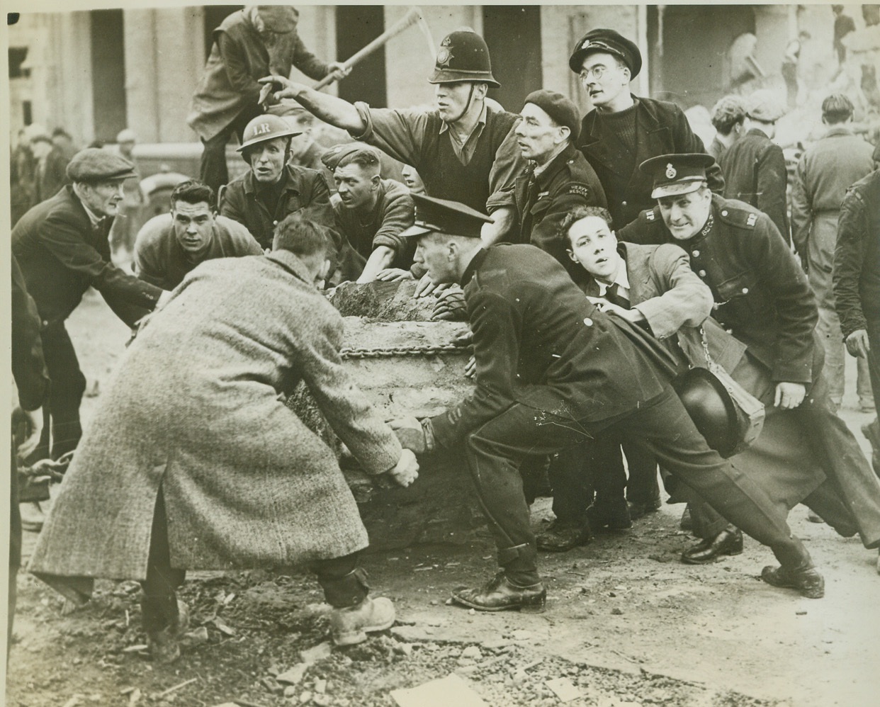 When Nazi Bombs Hit School, 2/5/1943. LONDON, ENGLAND -- Policemen, Civil Defense Workers, soldiers and civilians join in the search for survivors amid the debris of a London school bombed by the Nazis last month (January, 1943). Forty-two children and six teachers were killed and many others were injured when bombs fell on the school during a daylight raid in which many Nazi raiders flew at almost roof-top level to bomb and machine-gun the streets. Credit: (ACME);