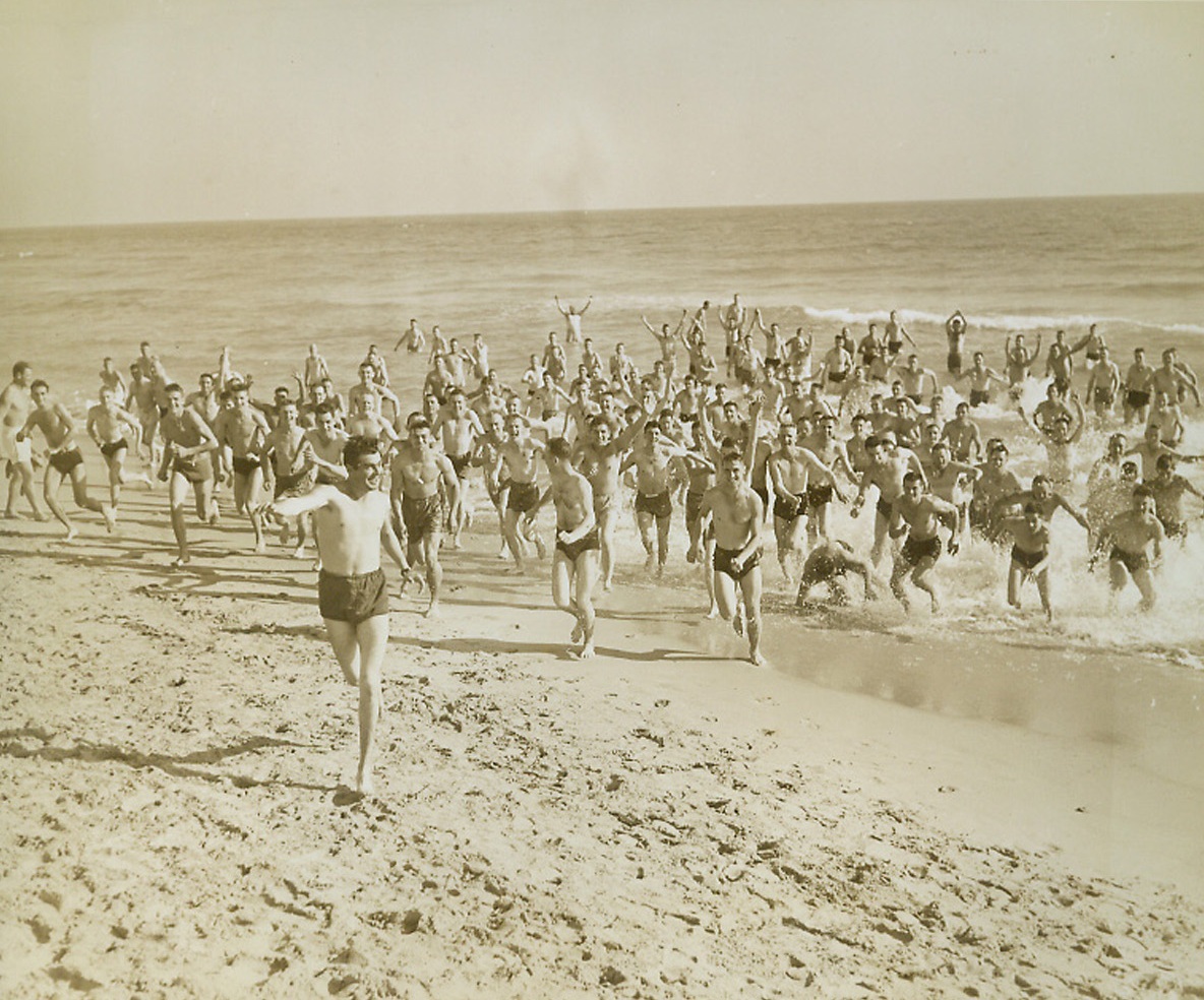Out of the Water, 2/5/1943. Miami Beach, Fla.—Soldiers of the Army Air Force Training Command dash out of the Atlantic Ocean onto the sands of Miami Beach, after a refreshing swim, to continue their daily program of calisthenics on the beach.Passed by censorsCredit: ACME.;