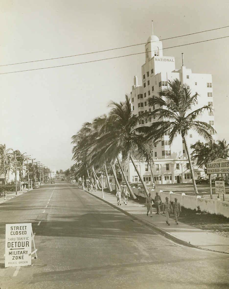 Detour—Street Closed, 2/5/1943. Miami Beach, Fla.—The sign at the left of the photo is a familiar one at Miami Beach these days. Once the playground of the rich, this section has been taken over by the Army Air Corps for training draftees, enlisted men and officer candidates. The area shown is Miami Beach’s famous Ocean Drive, looking north from Collins Avenue.Passed by censors.Credit: ACME.;