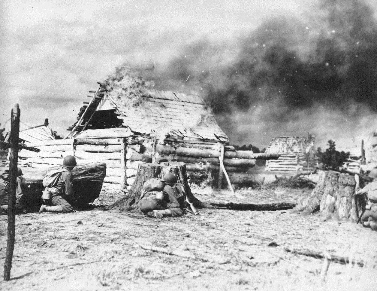 Wildcat Division Tastes Real War, 2/8/1943. Camp Rucker, Ala. -- Advancing under a barrage of live ammunition, units of the 81st (Wildcat) division were treated to a taste of actual warfare as they advanced across Lake Tholocco at Camp Rucker, Ala., in assault boats and stormed a "Nazi" village on the opposite shore. The exercise, planned to develop teamwork between all ground forces, saw nearly a thousand men in action as field artillery and infantry weapons threw live fire overhead.  Photo shows Infantrymen attacking the enemy village. They have set fire to the house with incendiary grenades. 2/8/43 (ACME);