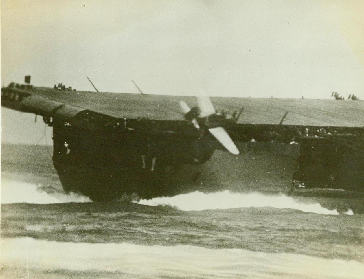 Concussion Throws Bomber Off U.S. Flattop, 2/20/1943. Overboard it goes! An enemy bomb hit on a U.S. aircraft carrier as it heeled over in a sharp turn sent this lone SED skidding off the flight deck on the starboard quarter. A U.S. Navy photographer on an accompanying warship snapped this picture just as the big Douglas Scout Bomber spilled over the side 2/20/43 (US Navy Official Photo From ACME);