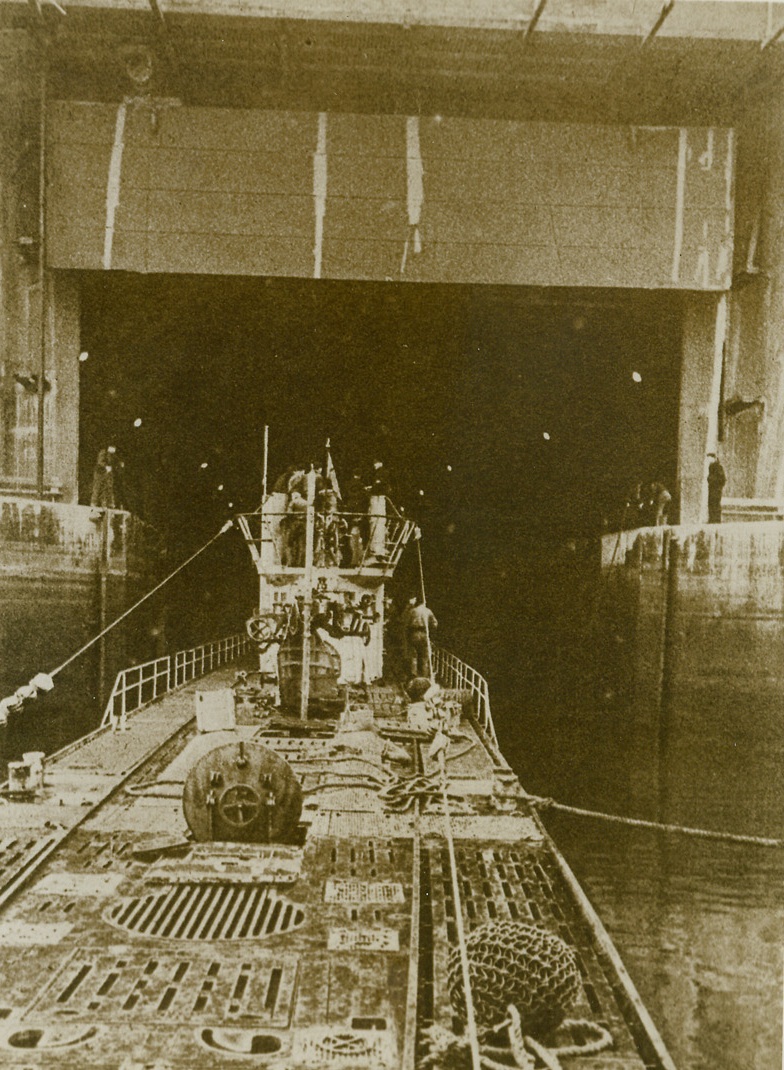 Nazi Sea Wolf Comes Home to its Den, 3/11/1943. A Nazi sub towed by tugs with French pilots moves slowly into a concrete bomb-proof shelter where it is lifted out of the water into a dry-dock in preparation for repair work. This photo was copied from a German propaganda magazine received through a neutral source. Credit: ACME.;