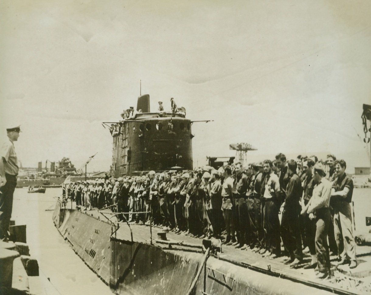 HEROES RETURN, 3/15/1943. This photo, released in Washington today, shows Marine raiders lining the deck of the U.S. submarine from which they conducted their surprise raid on Makin Island last August 17-18, as the ship pulled into Pearl Harbor. Submarine officers who took part in the successful attack, are shown looking down from the conning tower as they came into the harbor to receive the “well done” accolade from their commander-in-chief in the Pacific, Admiral Chester W. Nimitz.  Credit: U.S. NAVY PHOTO FROM ACME.;