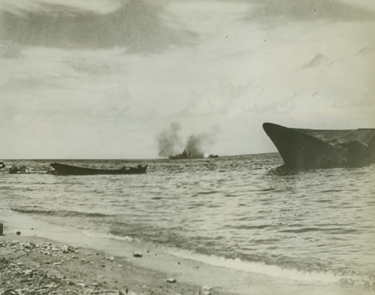 “SEA SHELLS” DUMPED IN LAPS OF JAPS, 3/8/1943. GUADACANAL—From land, air and sea, destruction was rained on the Japs who were intent on holding their positions on this island until recently. During the battles of November 13-15, an American warship (center) is shown shelling Nip positions. The beached Japanese ship, Kinugawa Maru, is shown in the foreground after it was blasted by U.S. forces.  Credit: ACME.;
