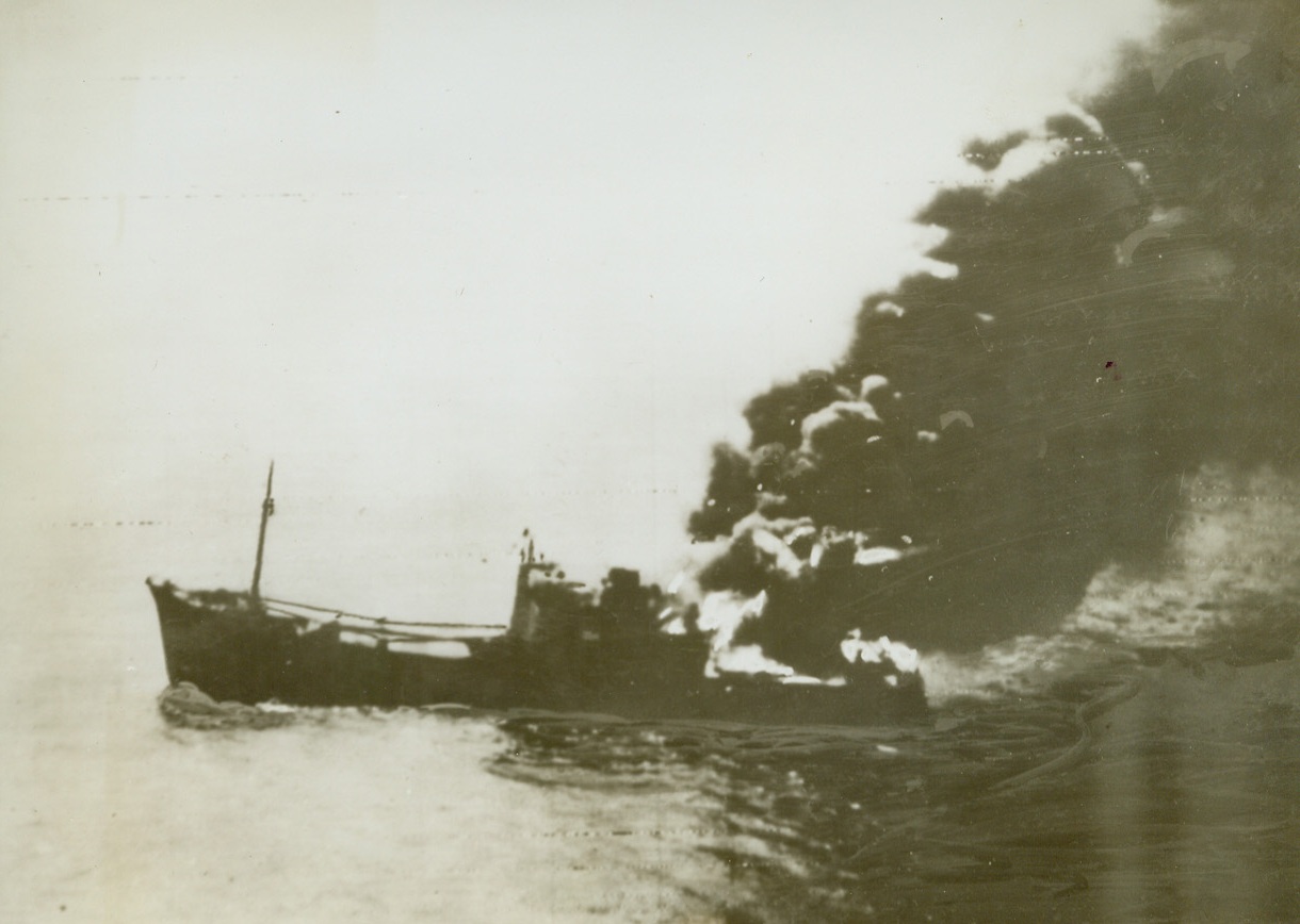 JOINING 21 OTHERS, 3/8/1943. In an official RAAF photo radioed from Melbourne, Australia, to San Francisco, one of the 22 Jap ships in a convoy wiped out in the Bismarck Sea goes up in flame and smoke after receiving hits from medium bombers. Credit: ACME.;