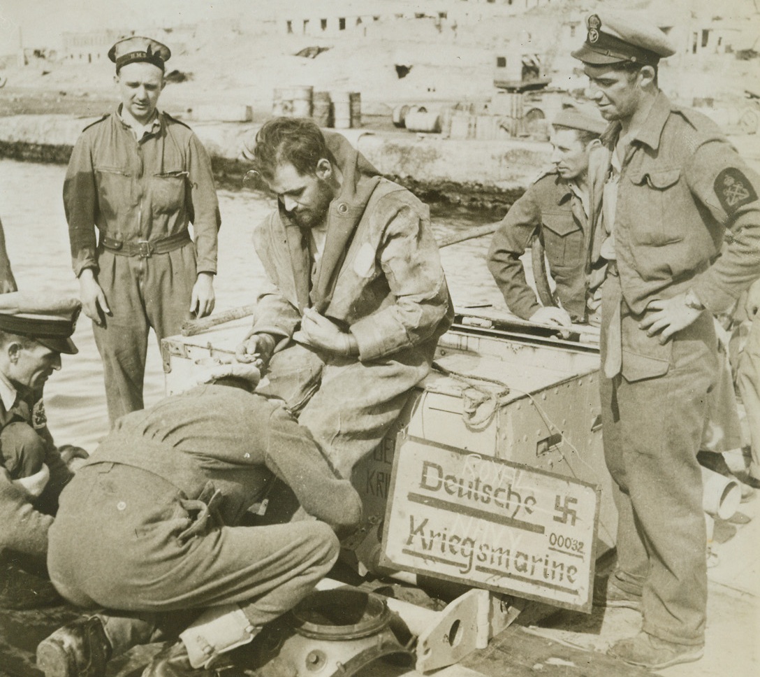Nazi Contribution to Allied Salvage Work, 3/14/1943. Tobruk, Libya - - Nazi signs deck the equipment utilized by a British diver about to explore the ground gloor of Tobruk harbor.  The enemy utilized the diver’s outfit before they were ousted from the Libyan coastal city.  The allies had a big clean-up job confronting them before they could fully make use of the harbor which was cluttered by blasted axis vessels. Credit line (ACME);