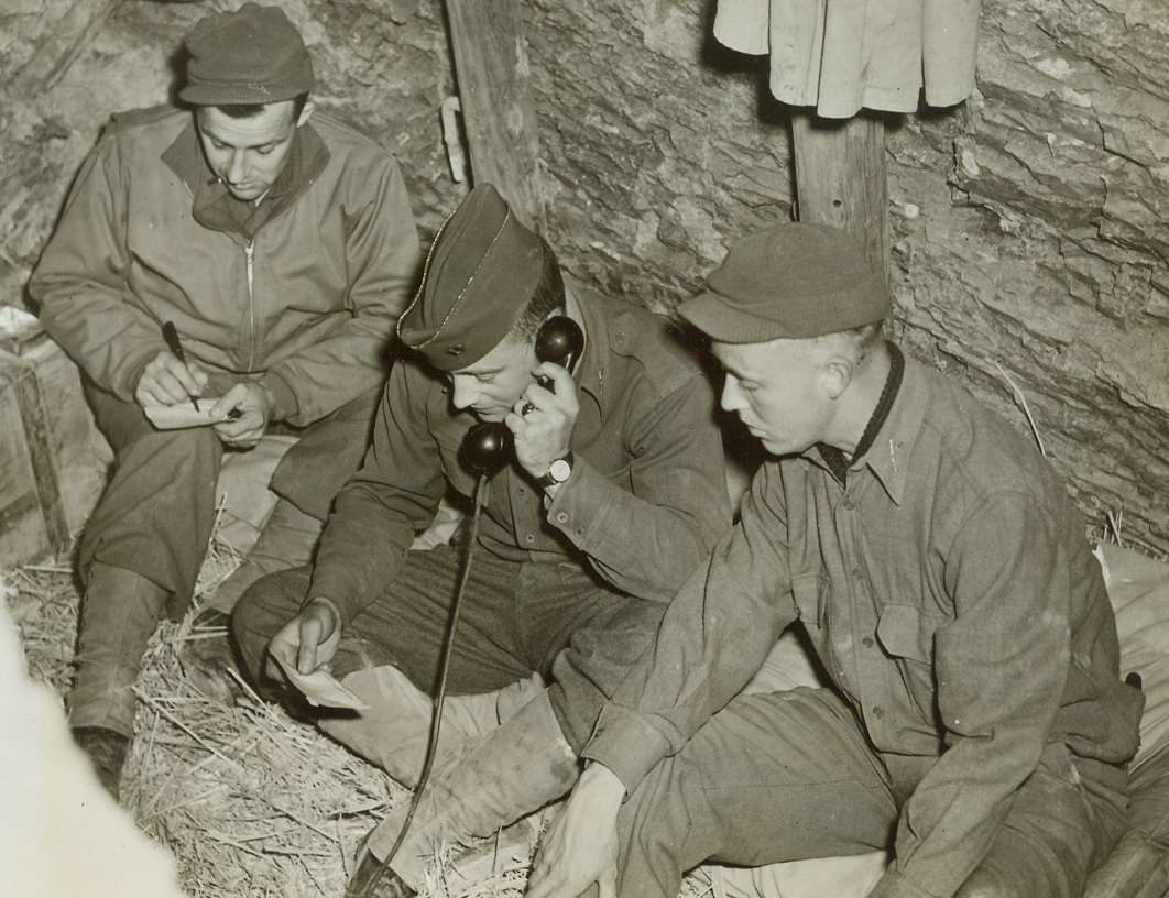 Communications in Tunisia, 3/2/1943. Tunisia - - A message is received via field telephone at an American outpost set up in a hillside dugout in Tunisia. Credit line (ACME);