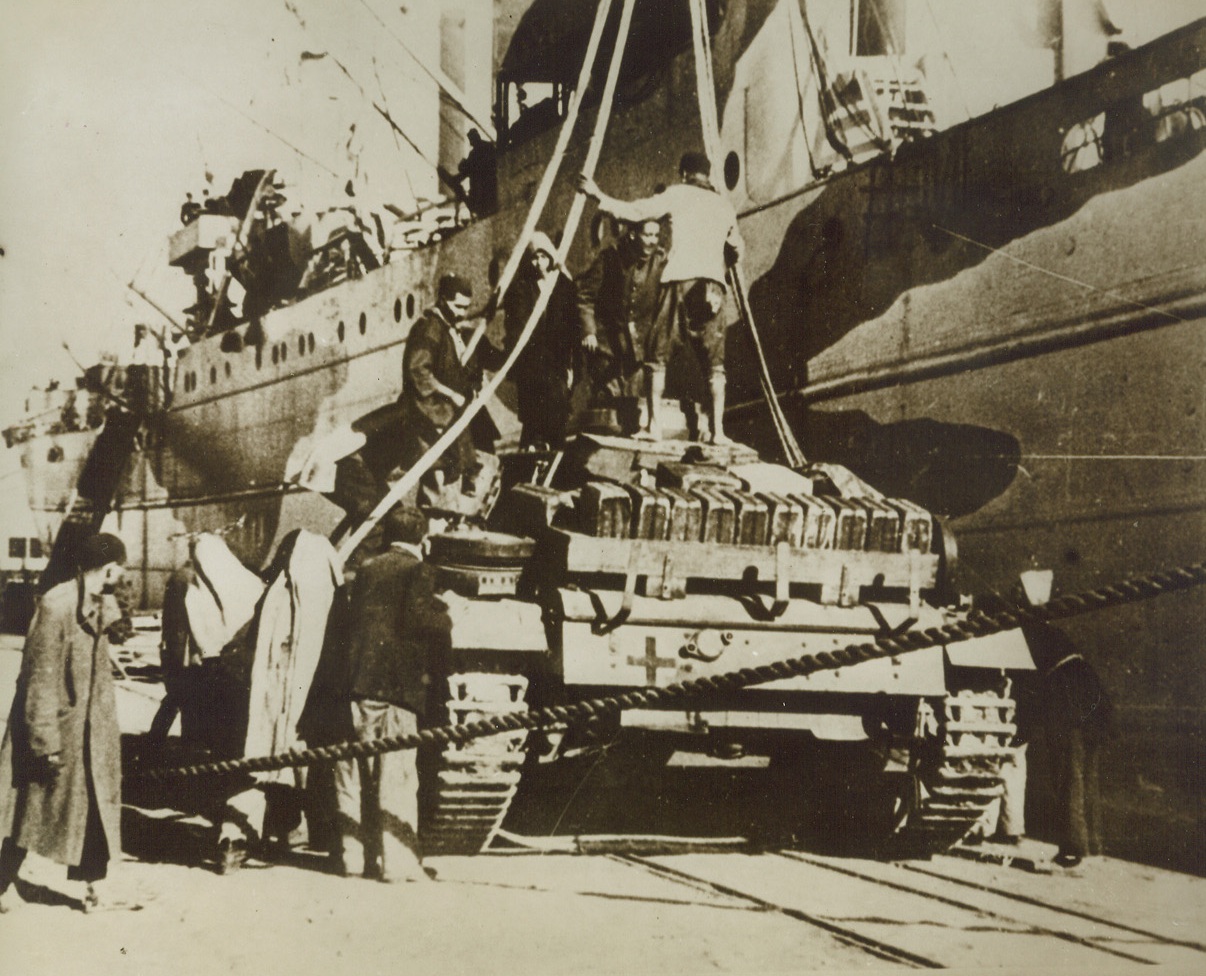 Tanks for the Afrika Korps, 3/1/1943. In this photo from a German source, tanks for Marshal Rommel’s Afrika Korps are shown as they were unloaded from a Mediterranean transport at a North Africa port.  Photo has just been received in New York by way of Lisbon. Credit line (ACME);