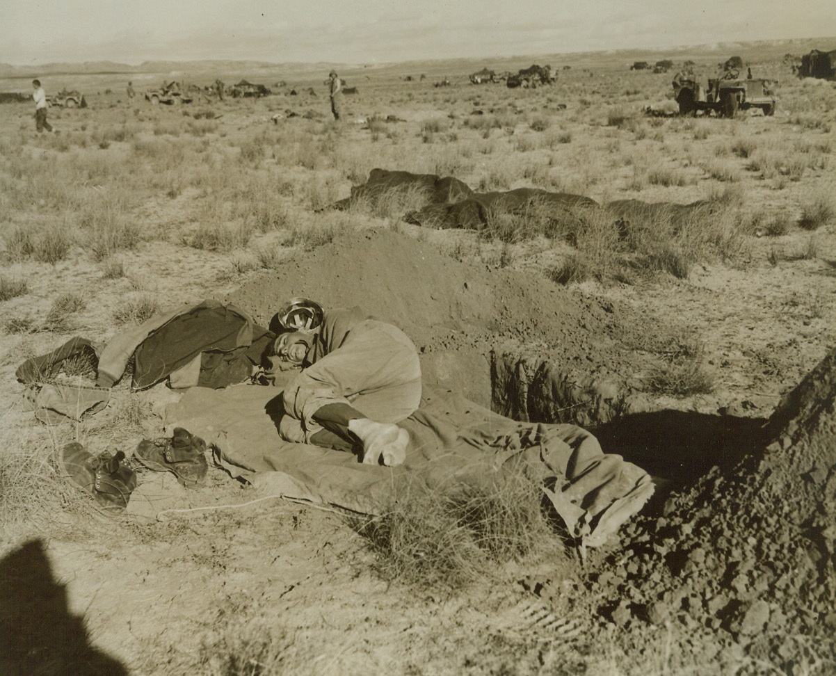 Asleep in the Field, 3/2/1943. Tunisia - - Pvt. David Chittenden, of New York city, after an all-night patrol, snatches a nap on the edge of his slit-trench, ready to roll for cover at the approach of enemy raiders. Credit line (ACME);