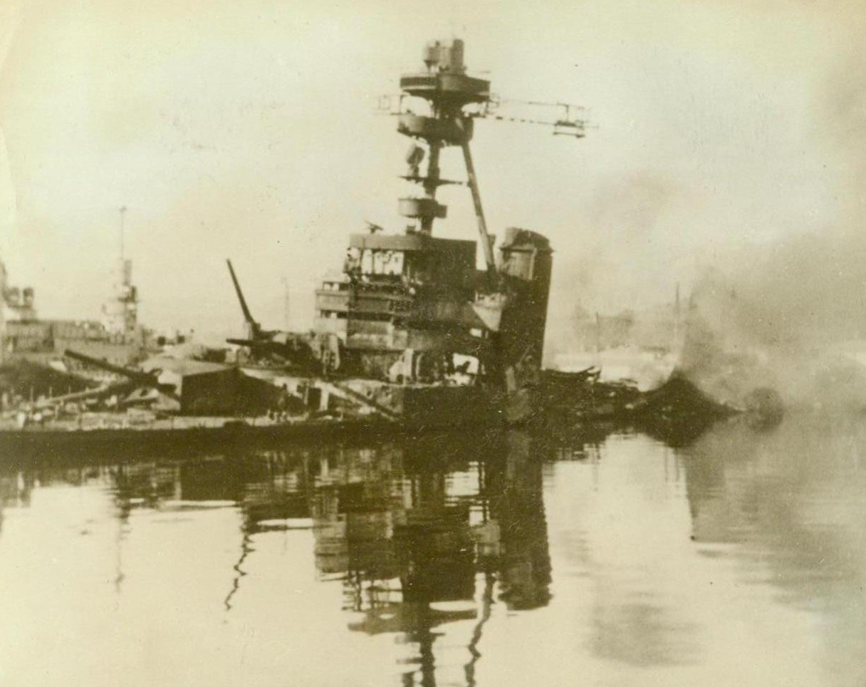 For the Honor of France, 3/2/1943. This photo, which was smuggled out of France and which reached New York today, shows the burned out hulk of a heavy French cruiser as it settled to the bottom of Toulon Harbor. It was one of more than fifty units of the French fleet destroyed or damaged last November 27 by their crews rather than let the warships fall into Nazi hands. Passed by censor. Credit: ACME;