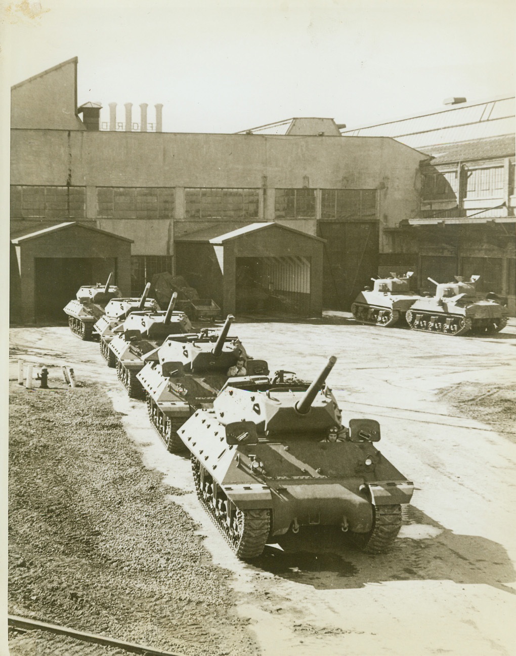 New Tank Busters for Uncle Sam, 3/11/1943. DETROIT, MICH. – A row of rangy, hard-hitting M-10 tank destroyers roll out of a Detroit plant of the Ford Motor Co. Faster, and with more hitting power than the medium tank, these new machines have already been in action and pronounced “hot stuff” by the Allies in North Africa. Note how different the M-10 is, than the M-4 medium tanks at right, (in background), which were also built by Ford. The two types of armored equipment come off the same production line. Credit: (ACME);