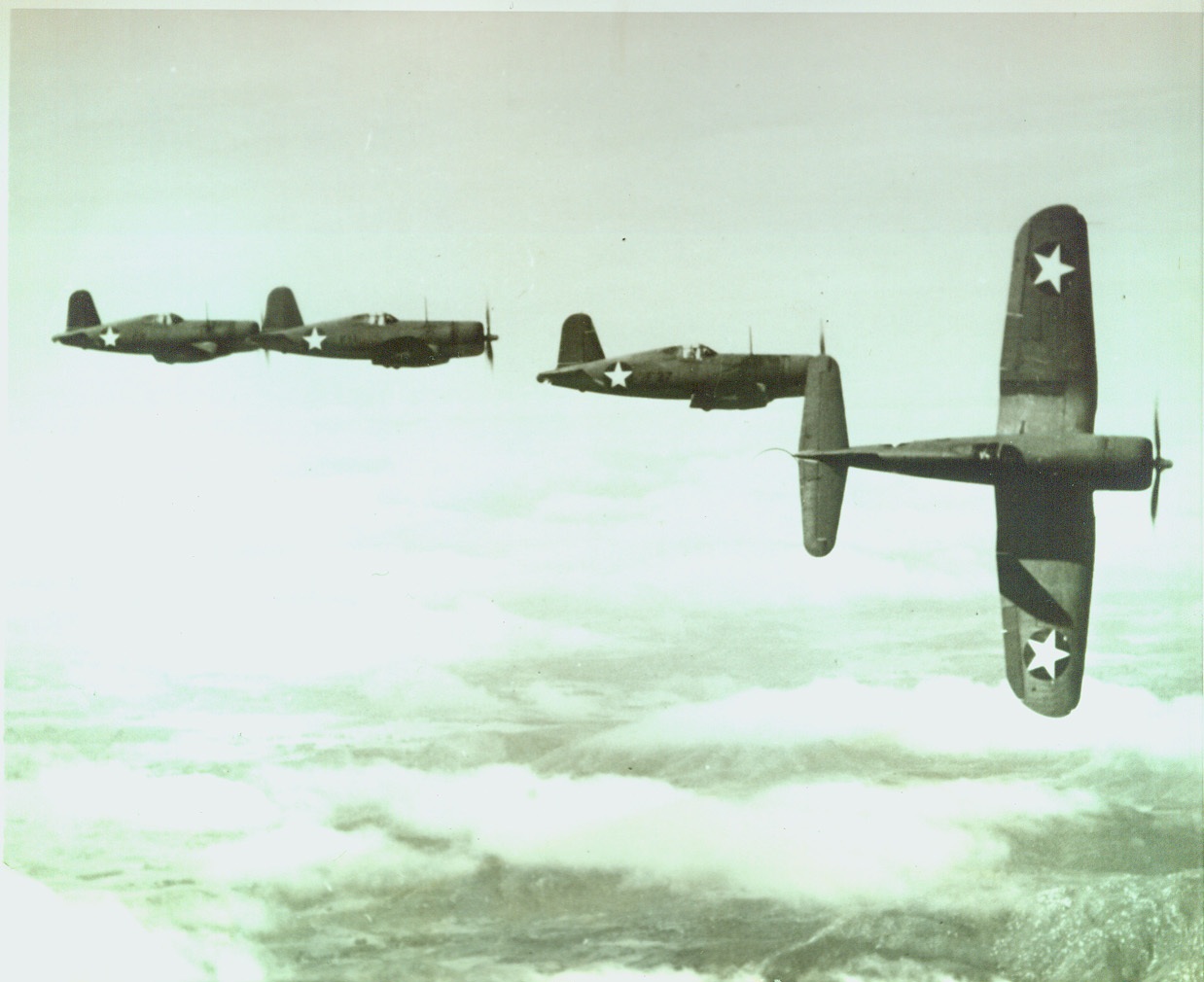 Corsairs Peeling Off, 3/23/1943. New U.S. Navy F4U-I Fighters peel off one by one from formation on high altitude practice flight. Known as Corsairs, the Vought-Sikorsky built planes are powerful additions to the nation's defense forces.;