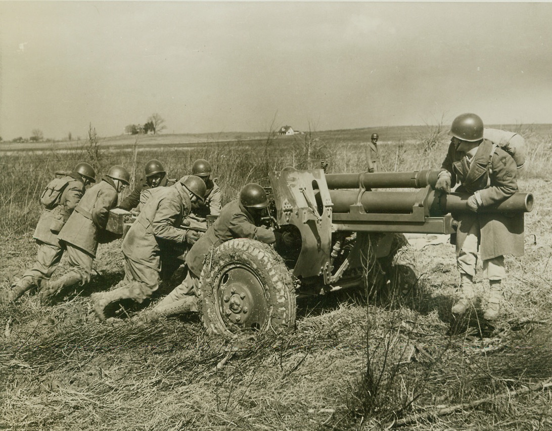 Union Workers Move Big Army Gun, 3/23/1943. Camp Atterbury, Ind.—The men moving this 105 mm Howitzer into place are union workmen—but not because the union insists on doing Army work. These men, war workers on leave from doing their own jobs, are guests at Camp Atterbury, Ind. Where they are spending three days learning something about Army life. So the Army obligingly puts them to work. Credit: ACME.;